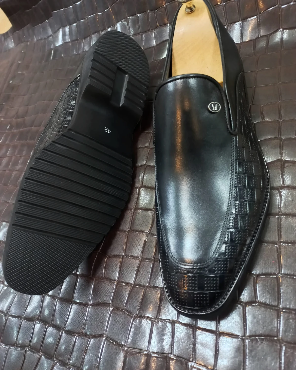 Black leather loafer with woven-effect apron and ridged sole
